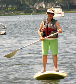 Woman doing stand up and paddle on West Bay.